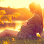 Schwangere Frau in der Abendsonne
